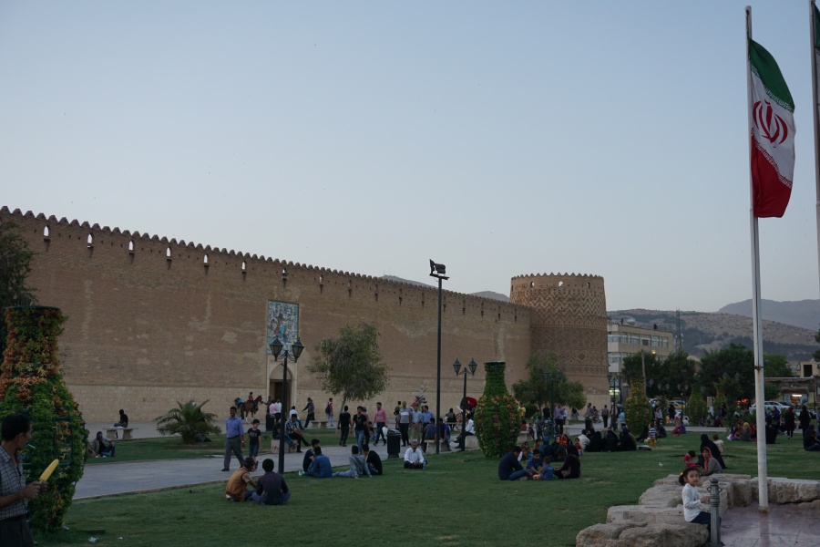 Vor der alten Festung in Shiraz fuellen sich die Rasenflaechen am Abend